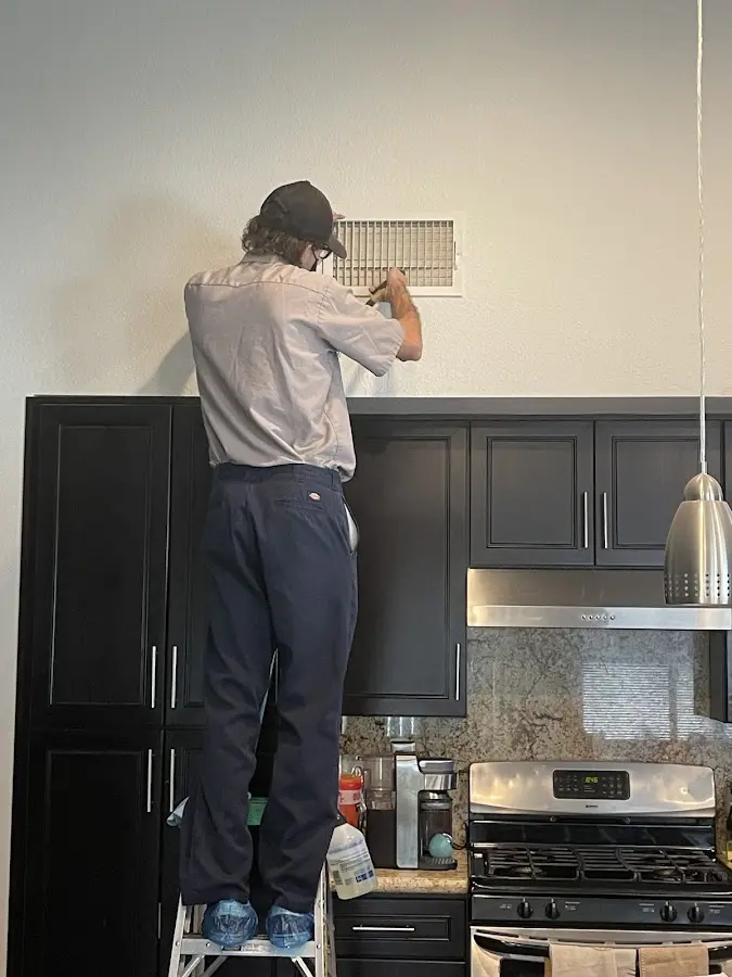 Technician inspecting an air vent during HVAC service in Markham